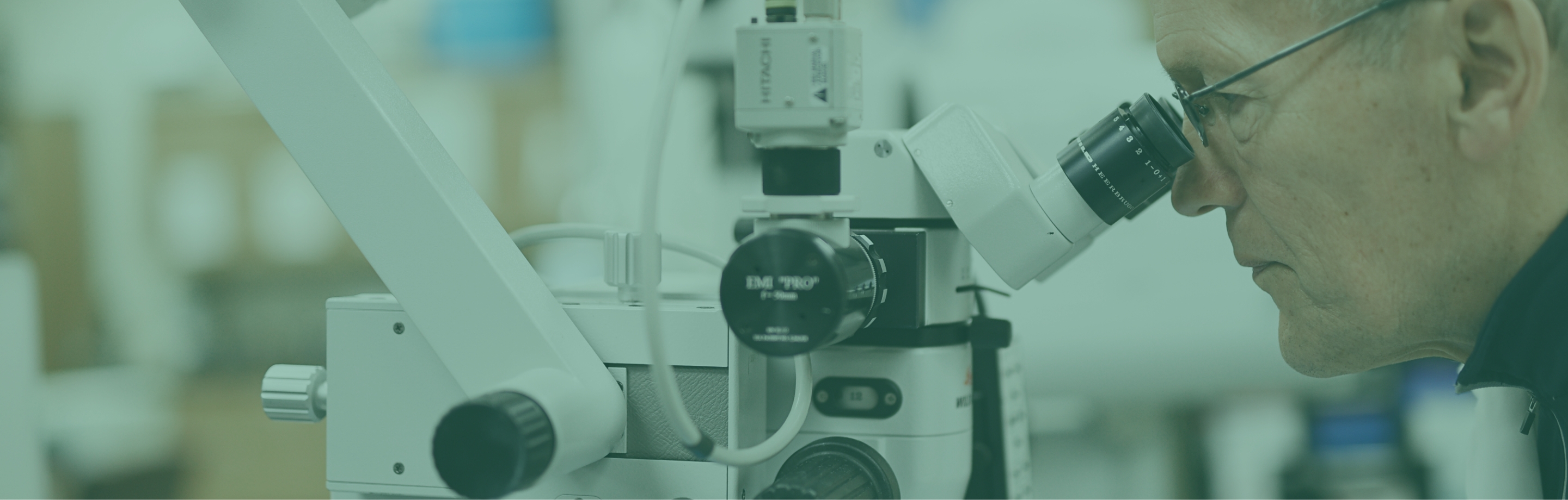 man looking through a microscope in a lab